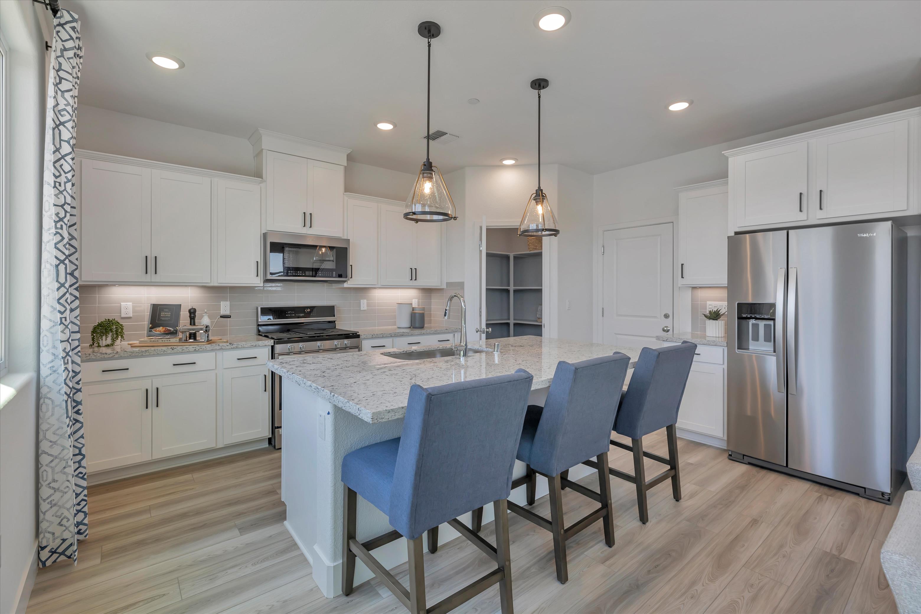 A kitchen with a dining table and chairs.