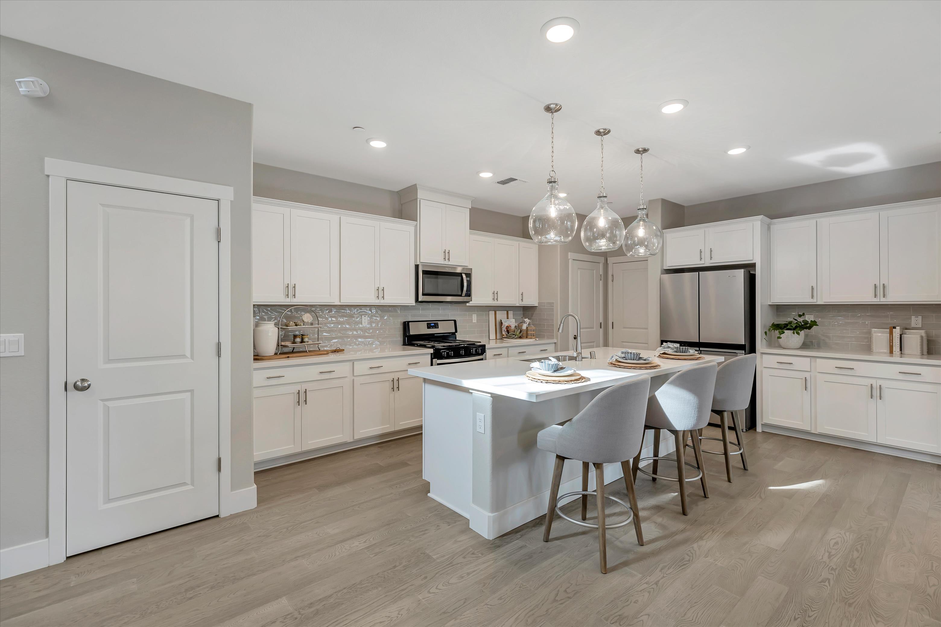 A kitchen with white cabinets.