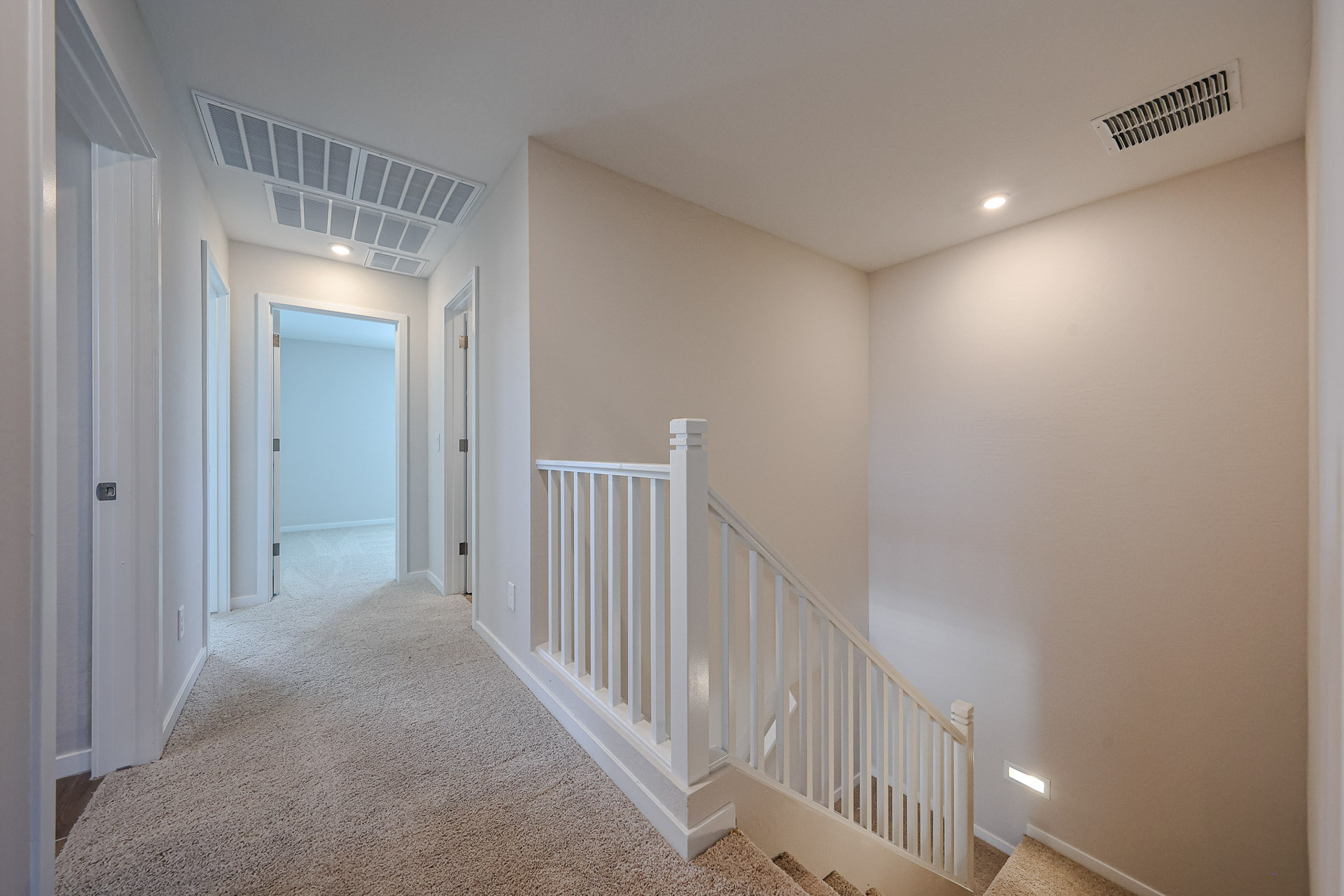 A hallway with white railings.
