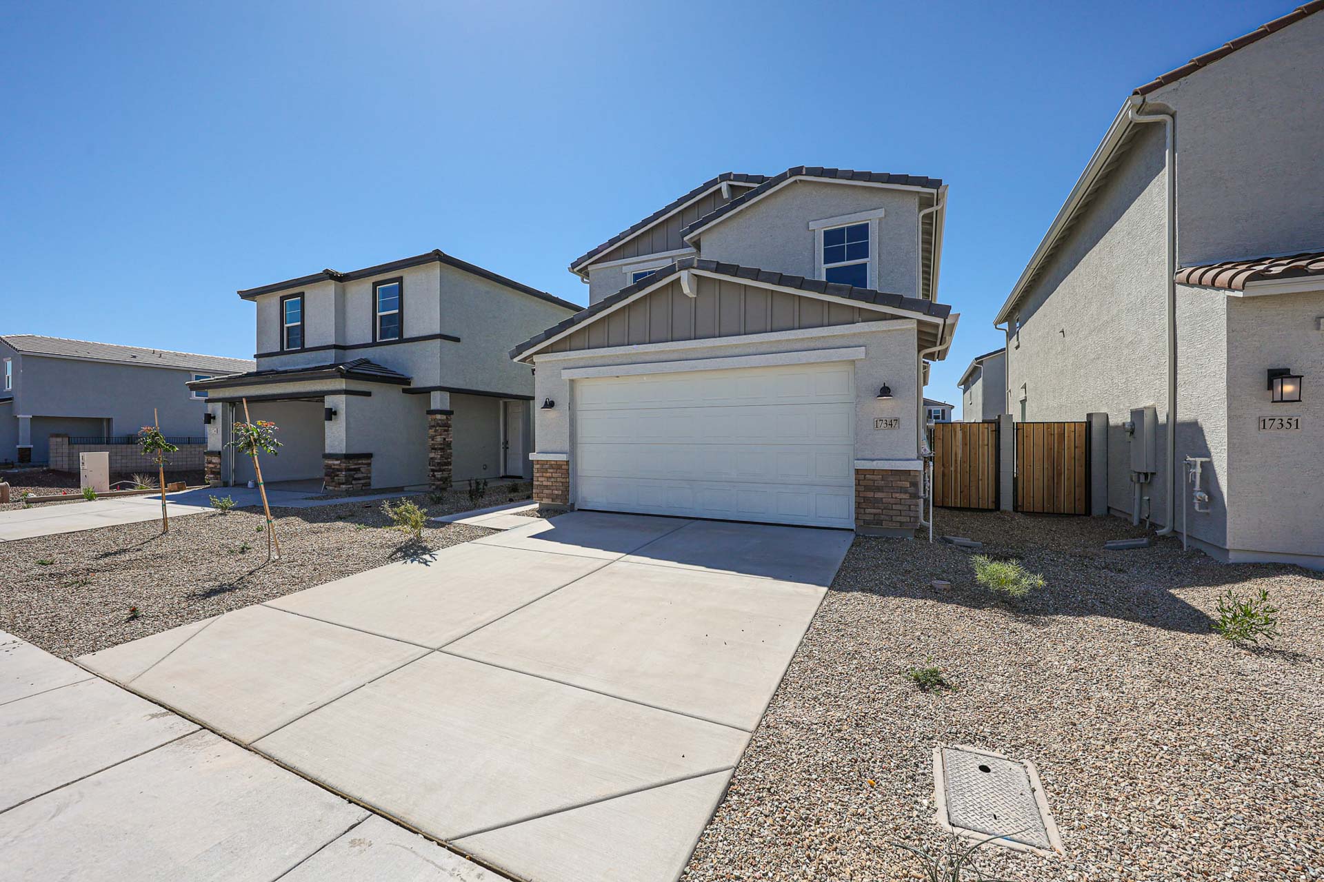 A driveway with a garage and a house in the background.