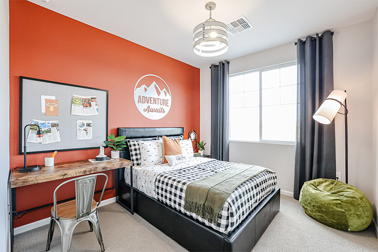 A bedroom with a bed and a desk.