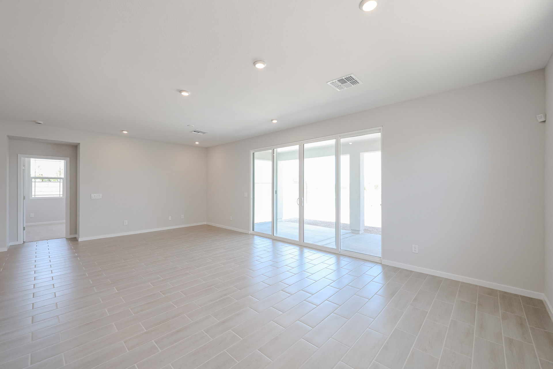 A room with white walls and a wood floor with a wood floor.