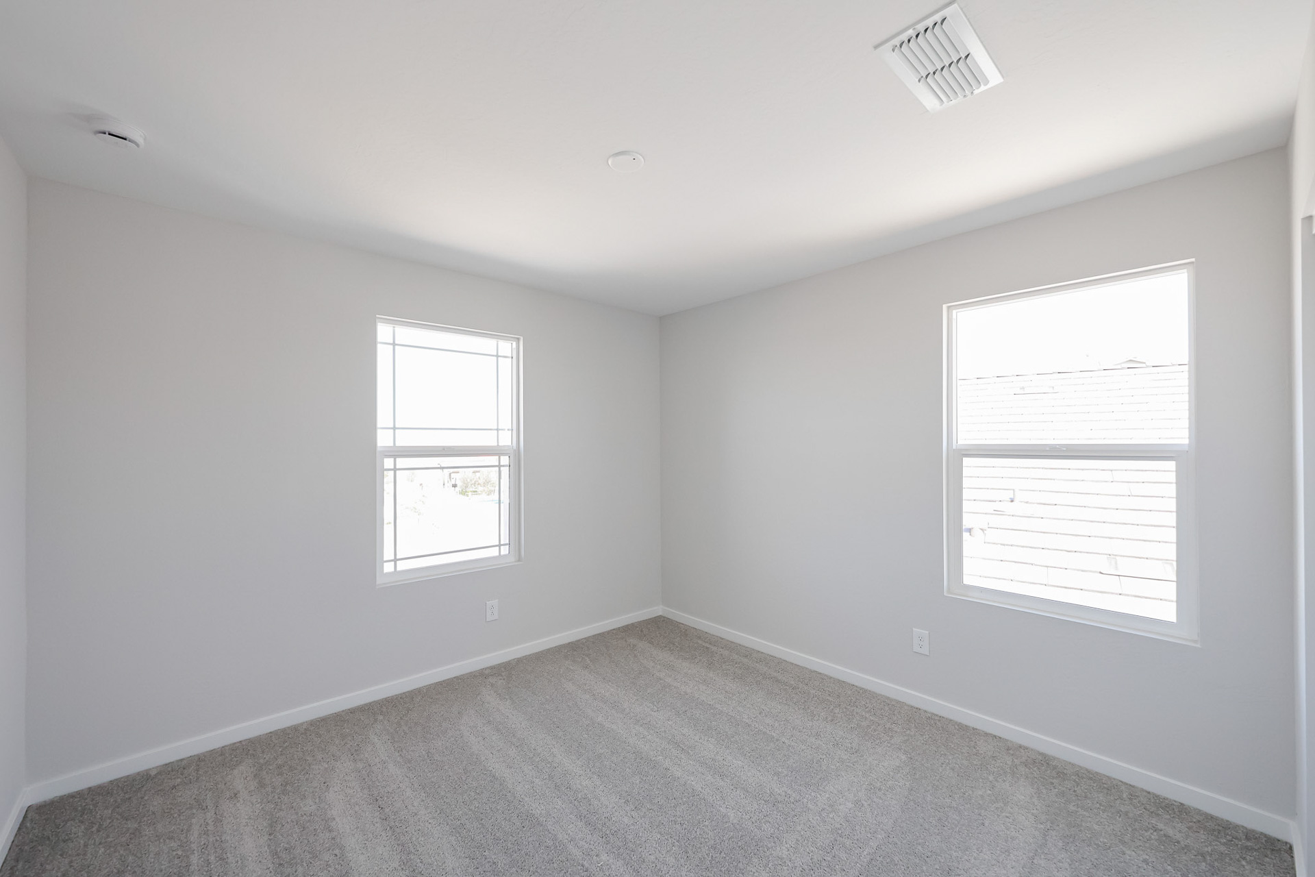 A room with a carpet and windows.