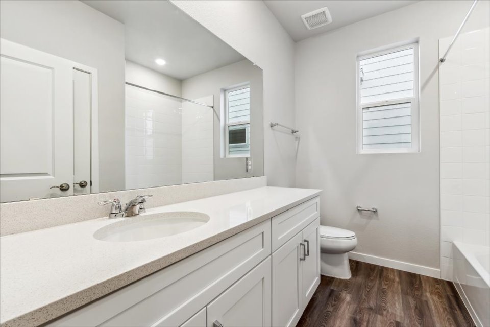 A bathroom with a sink toilet and a shower.