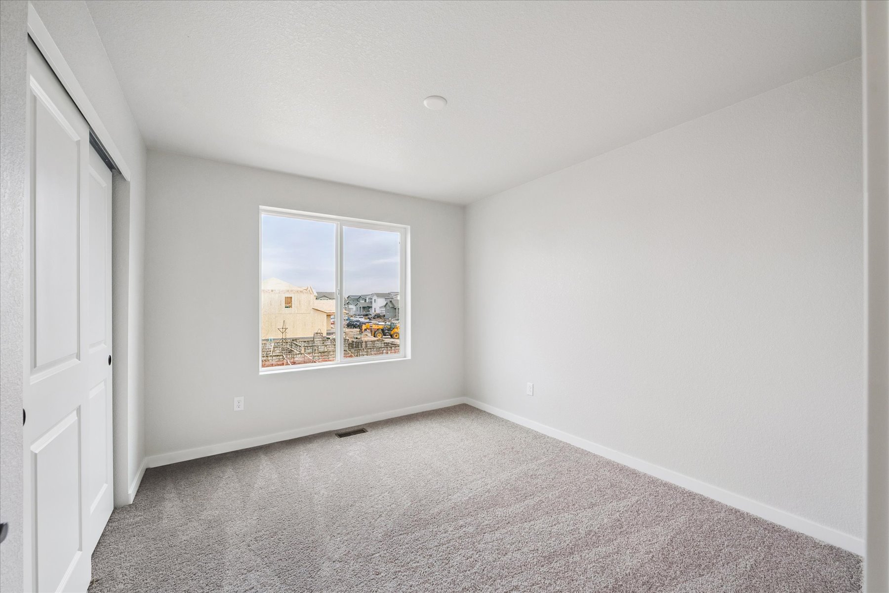 A room with a window and carpet.
