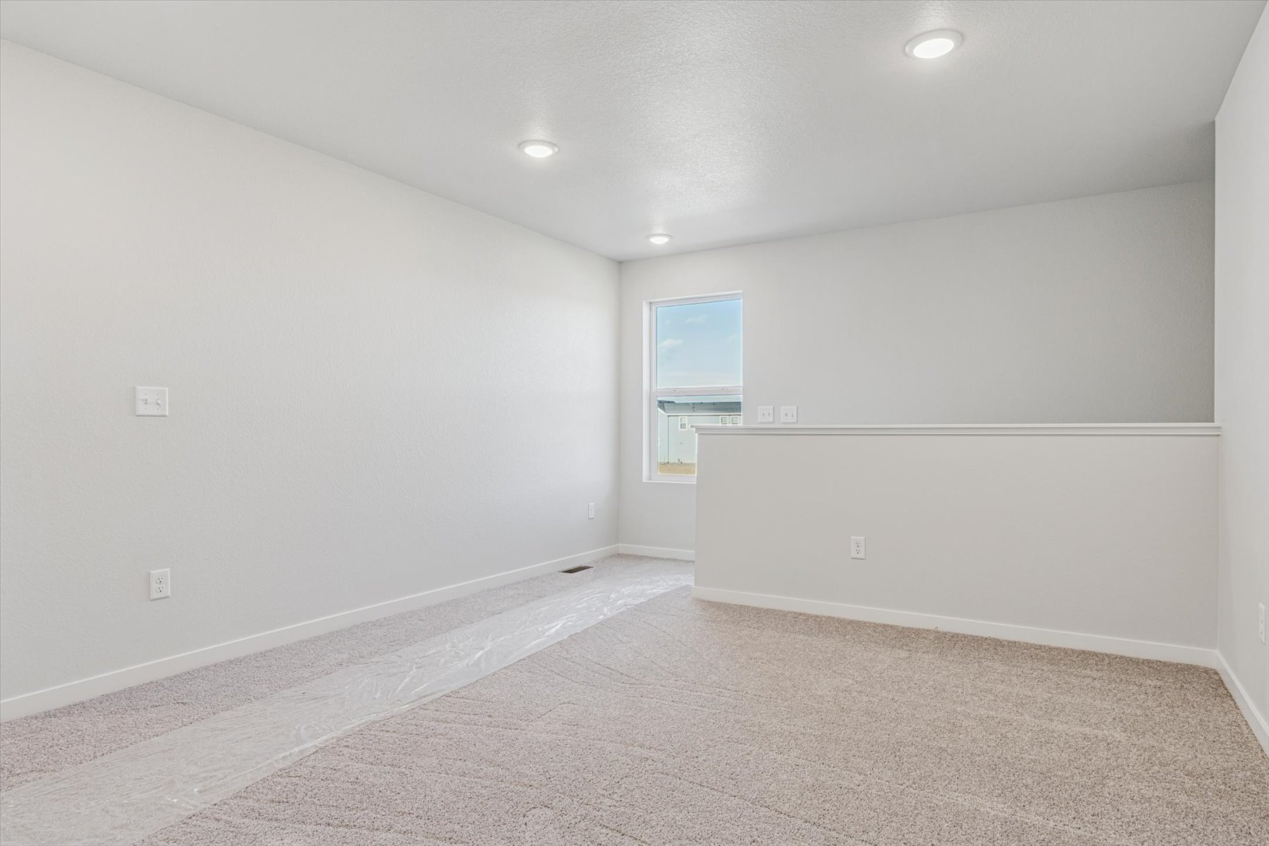A room with a carpet and a window.