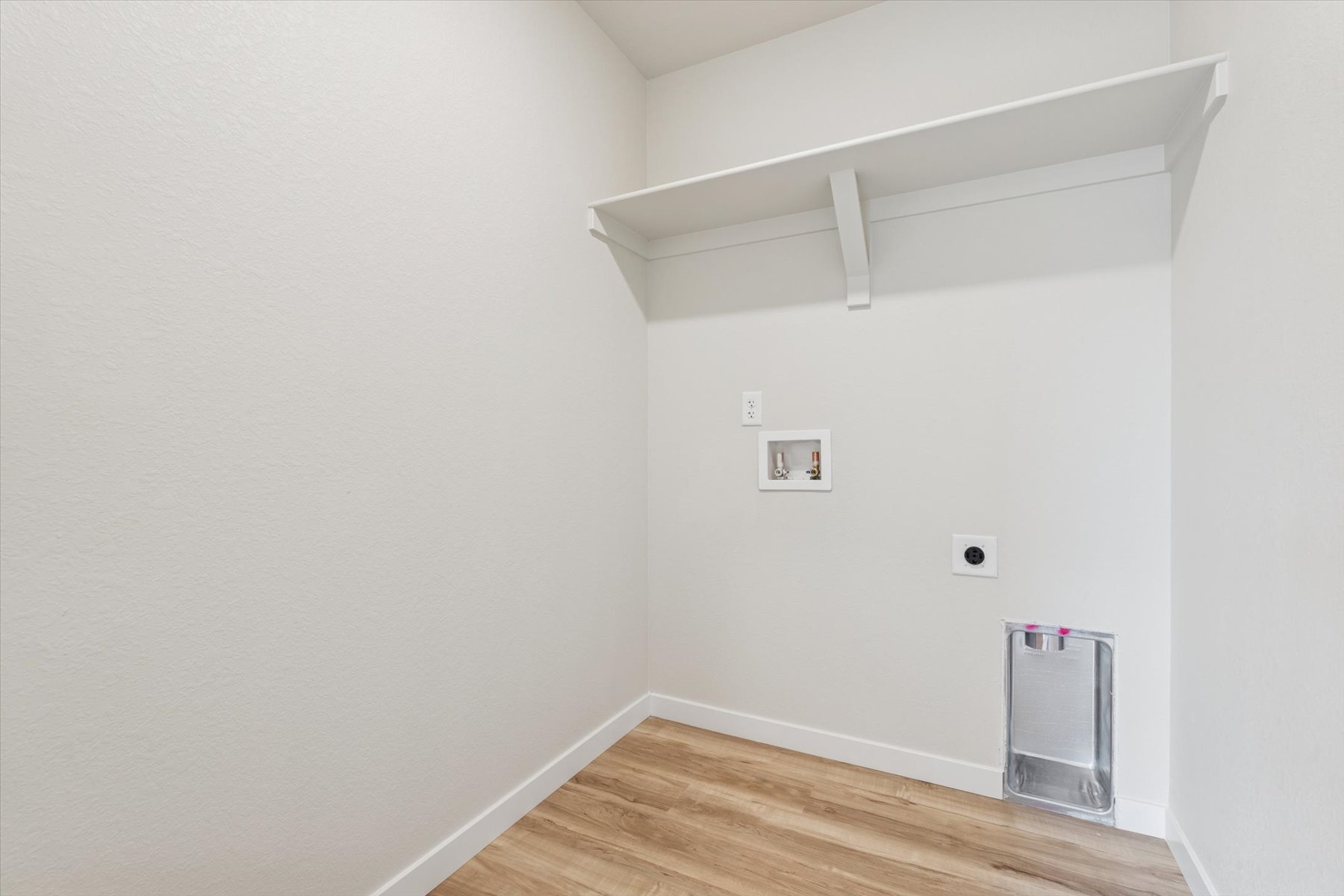 A room with a wood floor and white walls.