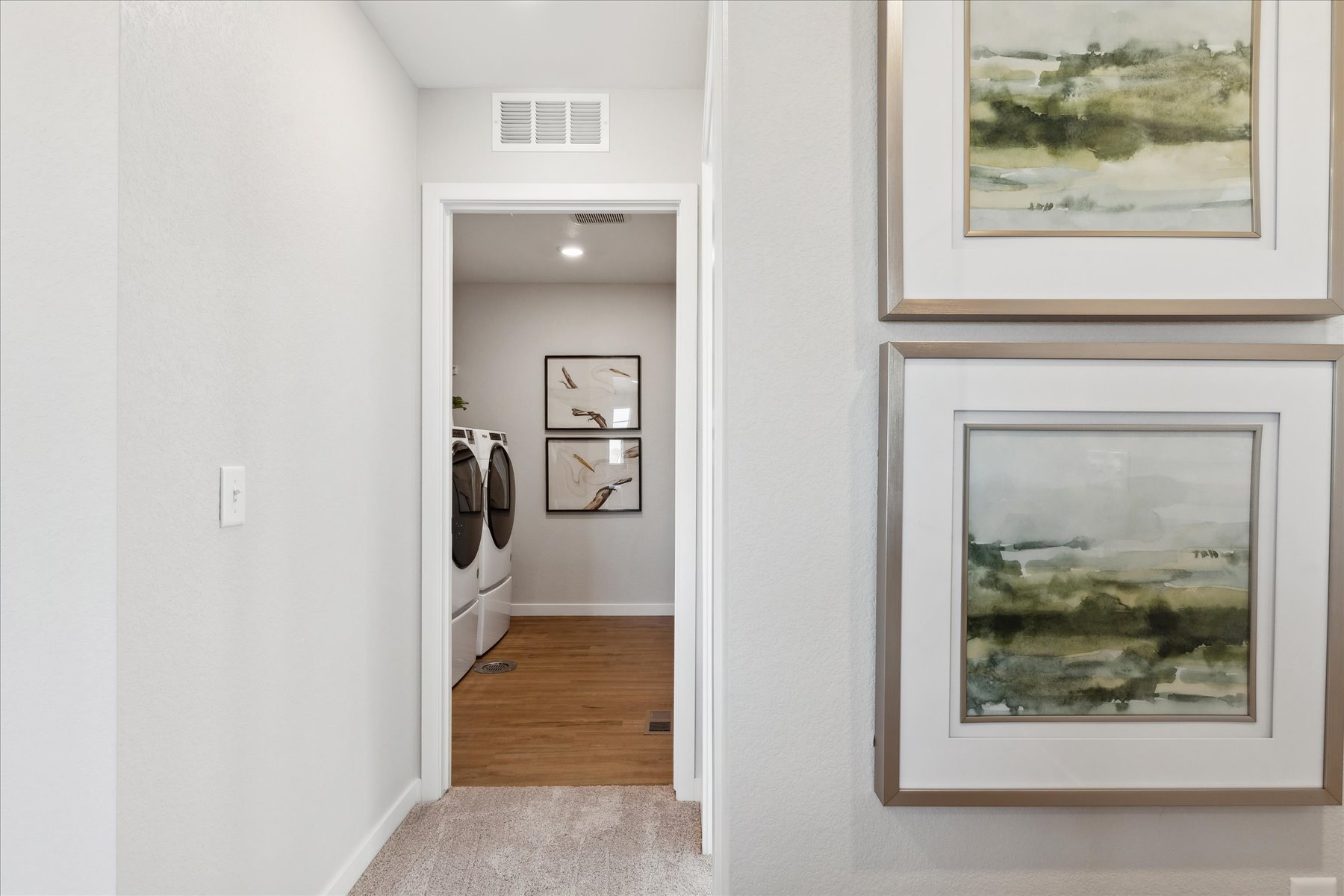 A room with a mirror and a shelf with pictures on it.