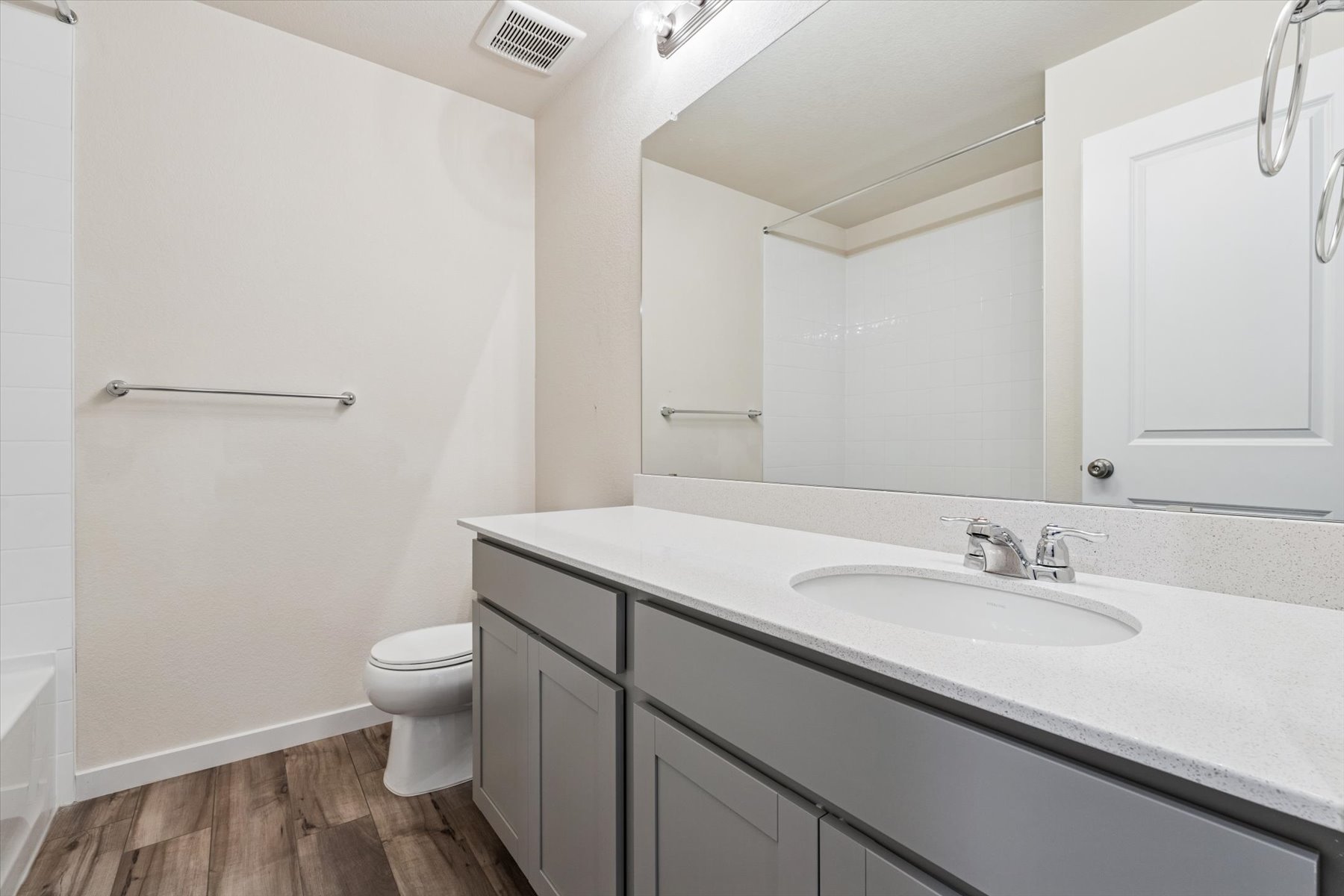 A bathroom with a sink toilet and mirror.