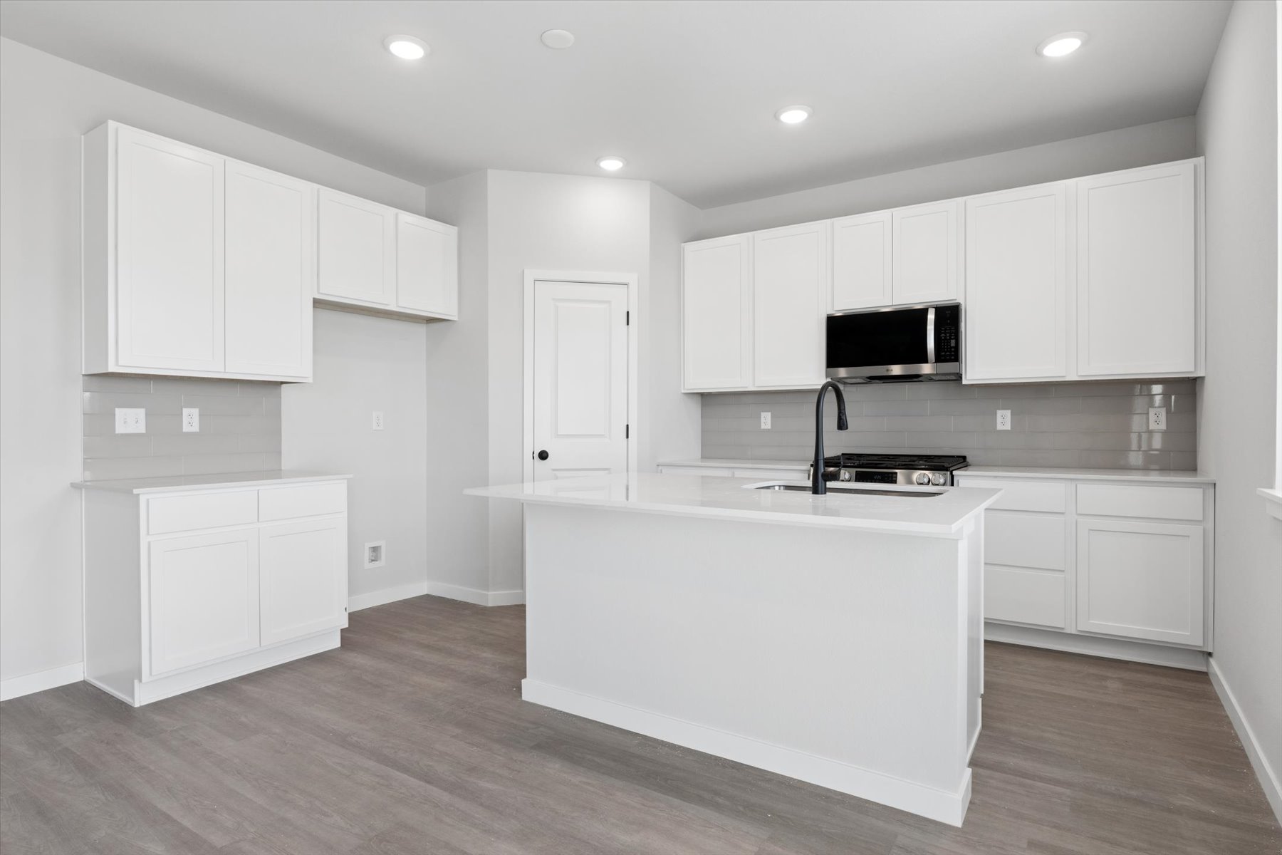 A kitchen with white cabinets.