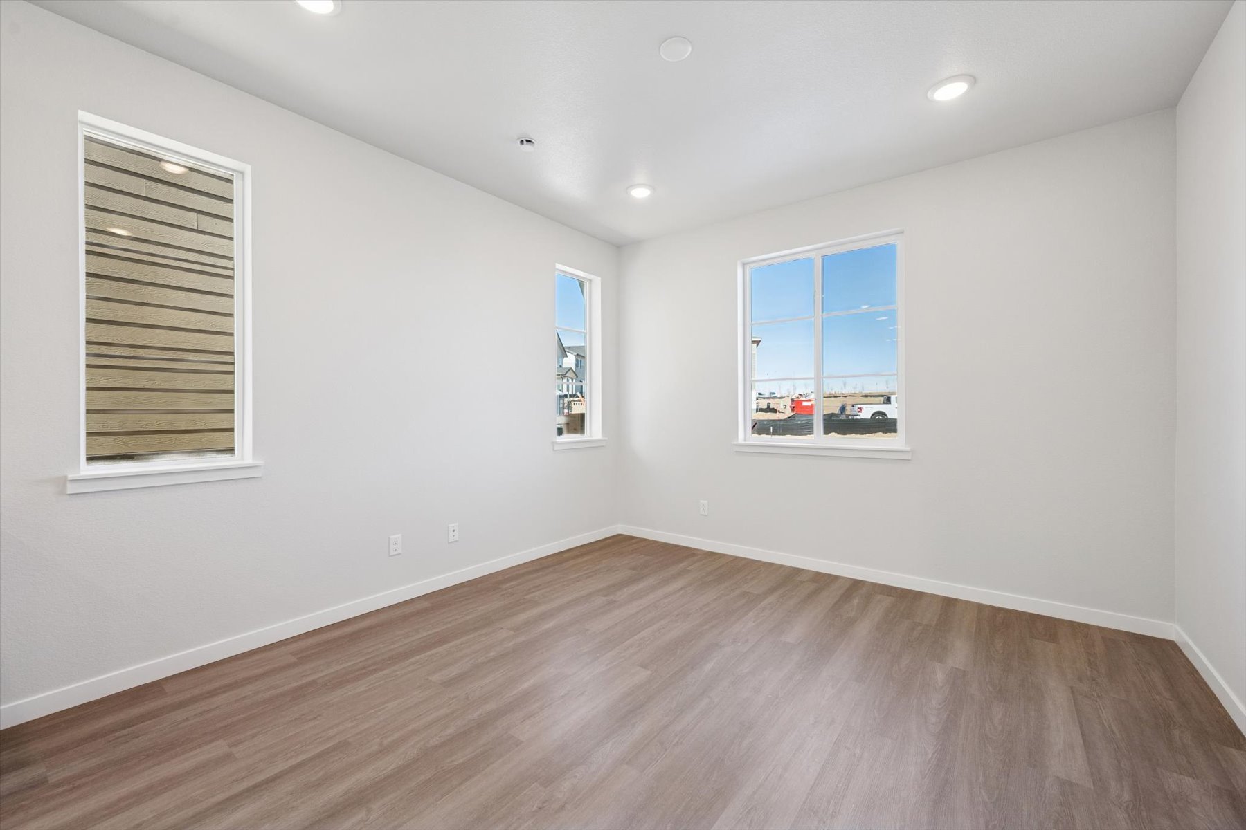 A room with a wood floor and a wood floor with a window.