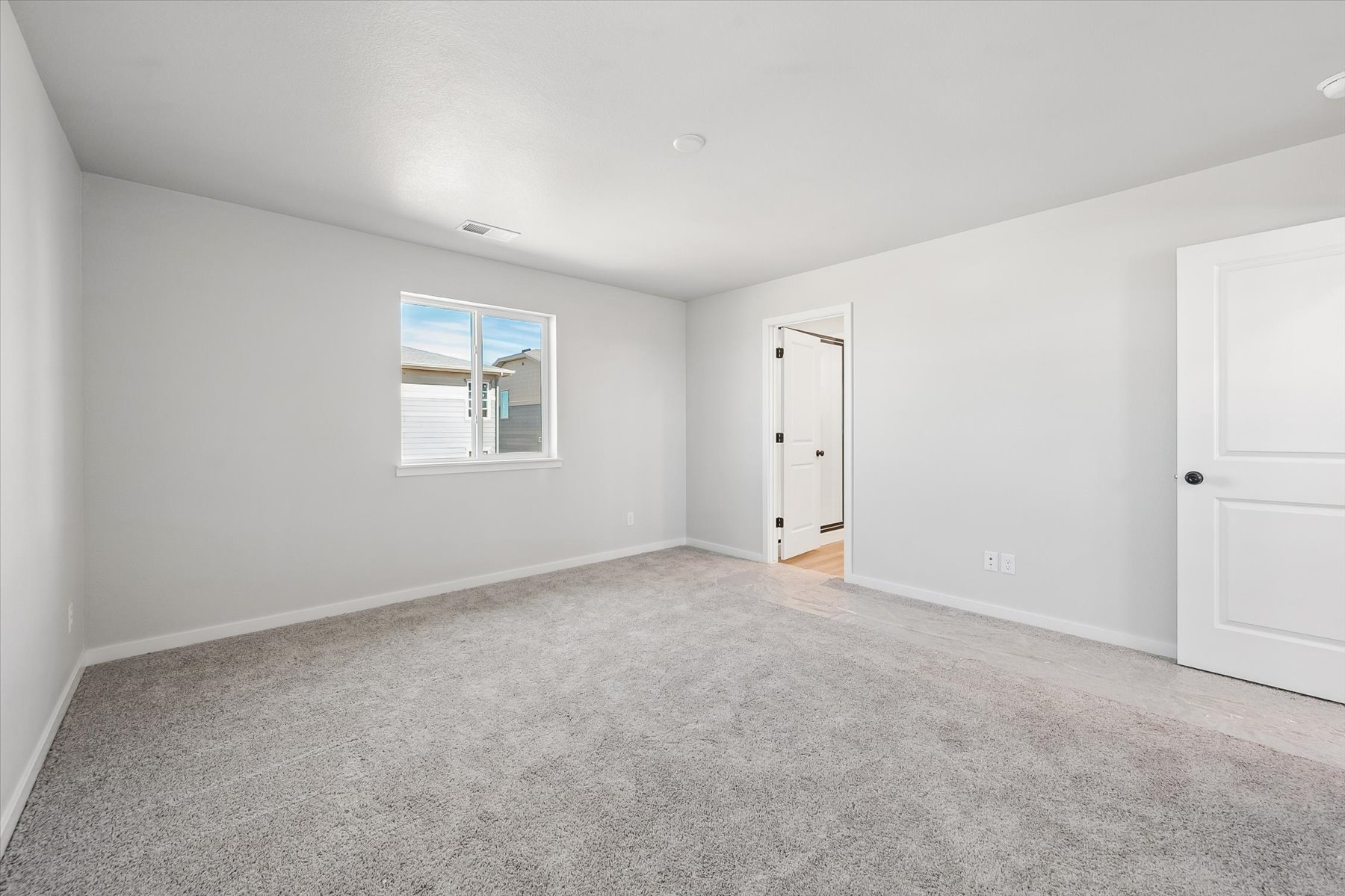 A room with white walls and a window.