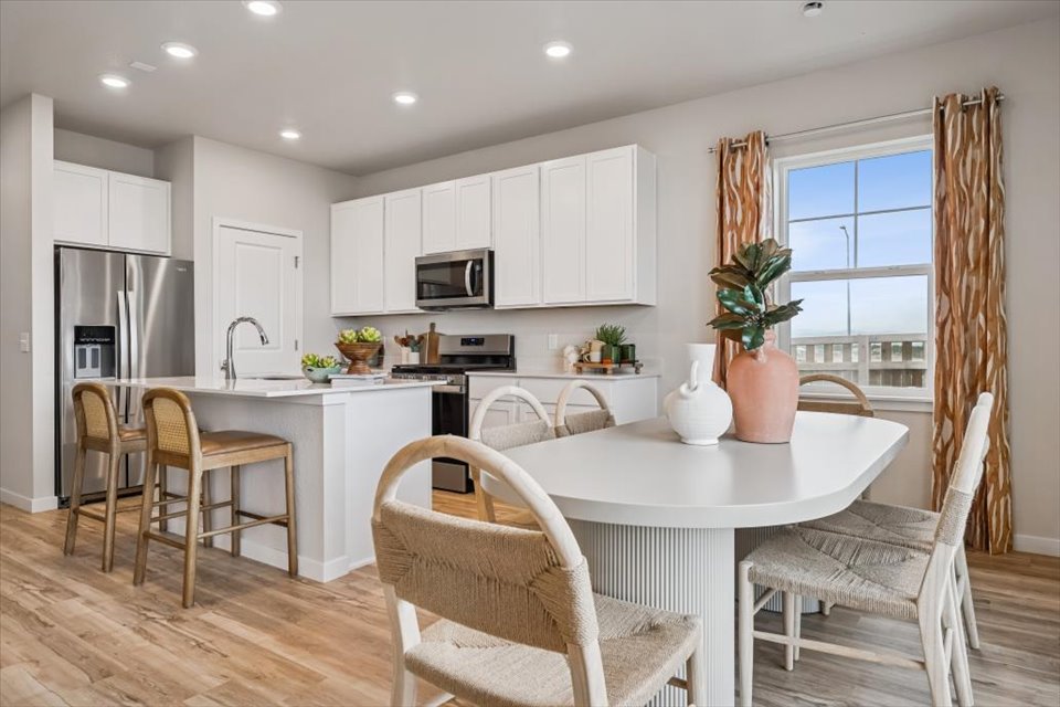 A kitchen with a dining table and chairs.