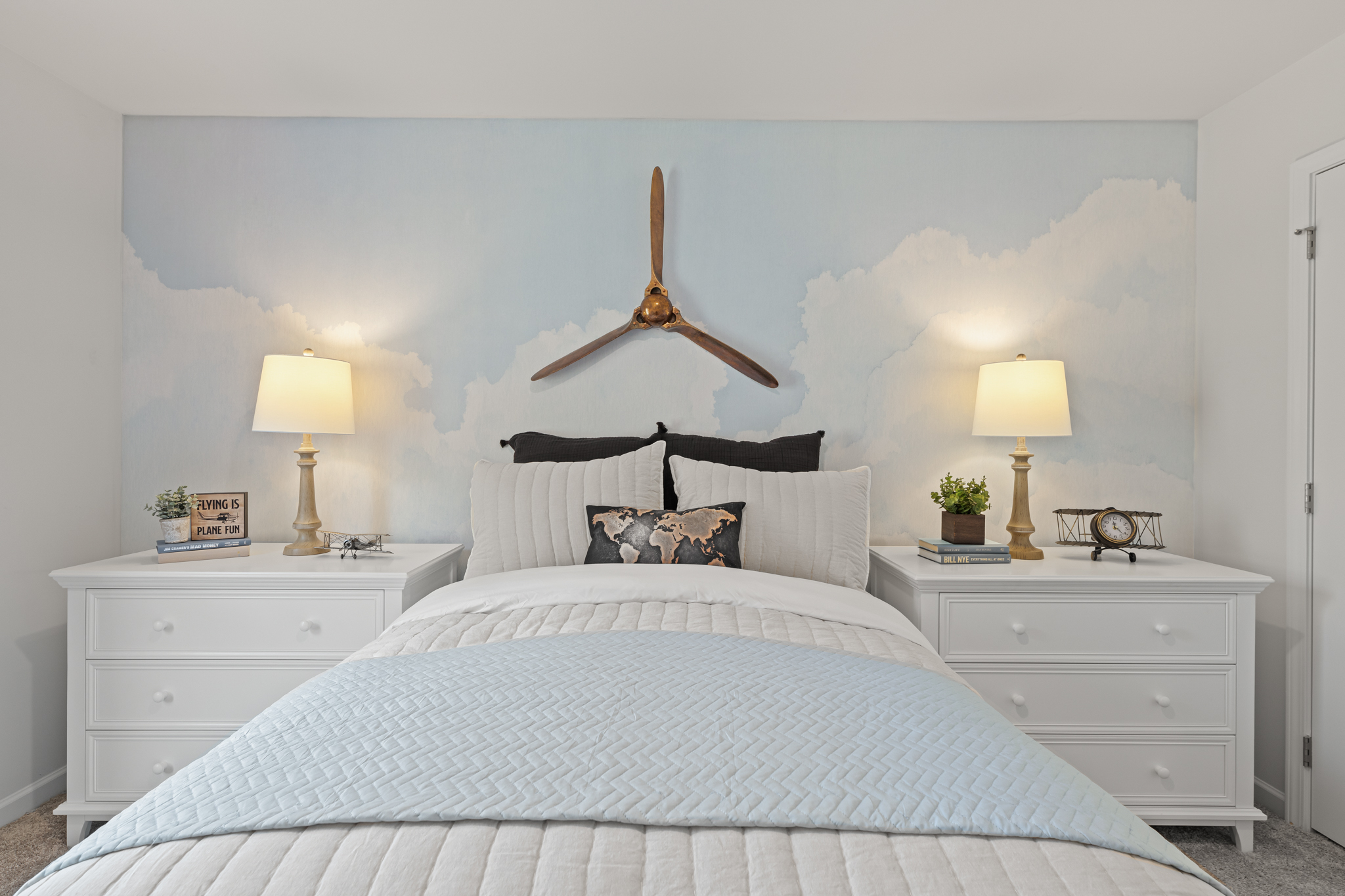 A bed with a white bed spread.