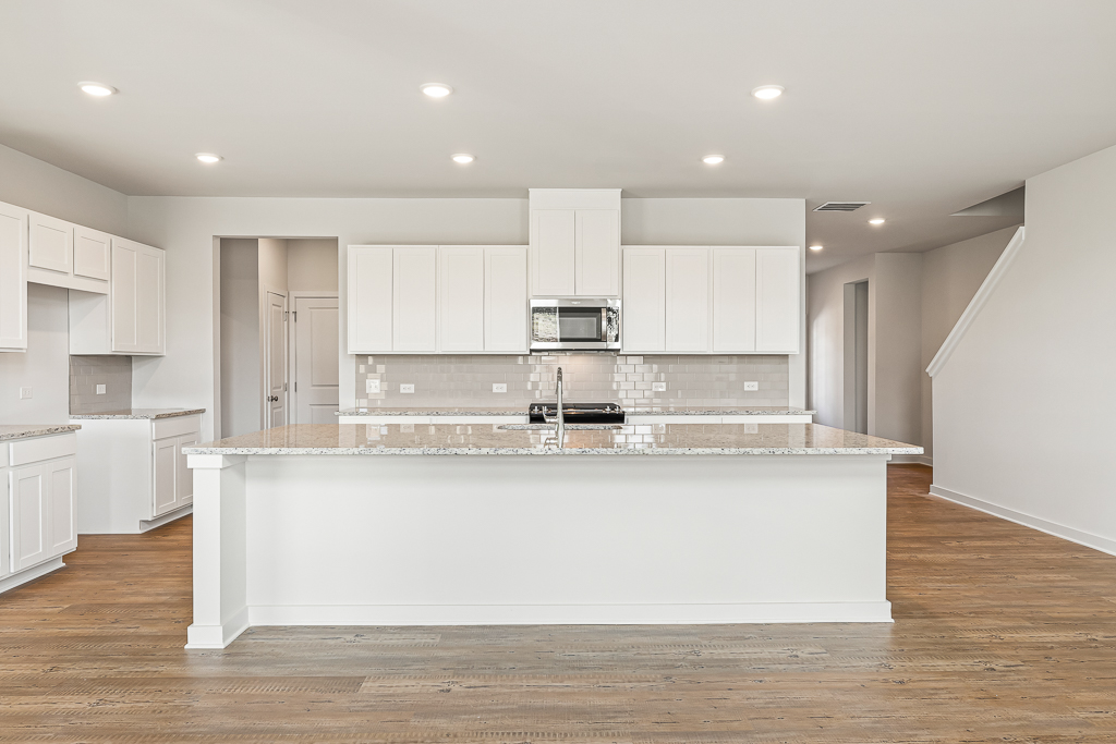 A kitchen with white cabinets.