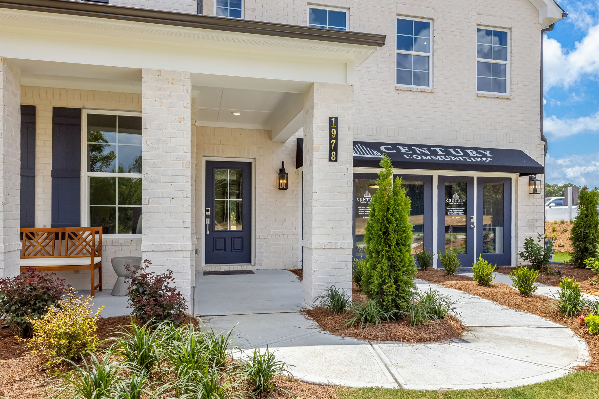 A building with a bench and a tree in front of it.