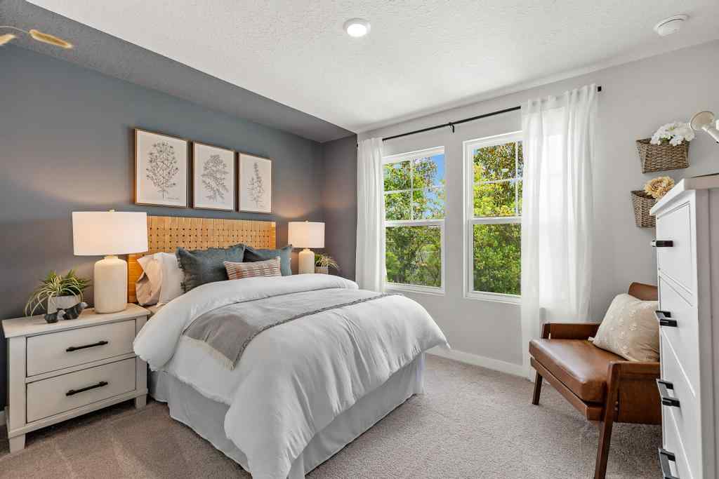 A bedroom with a bed and a chair.