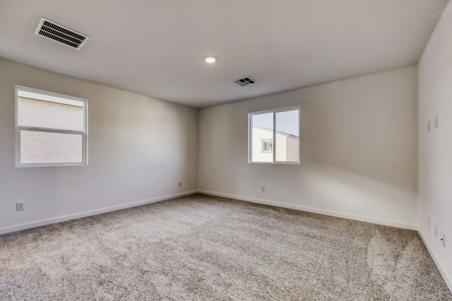 A room with a carpet and a window.