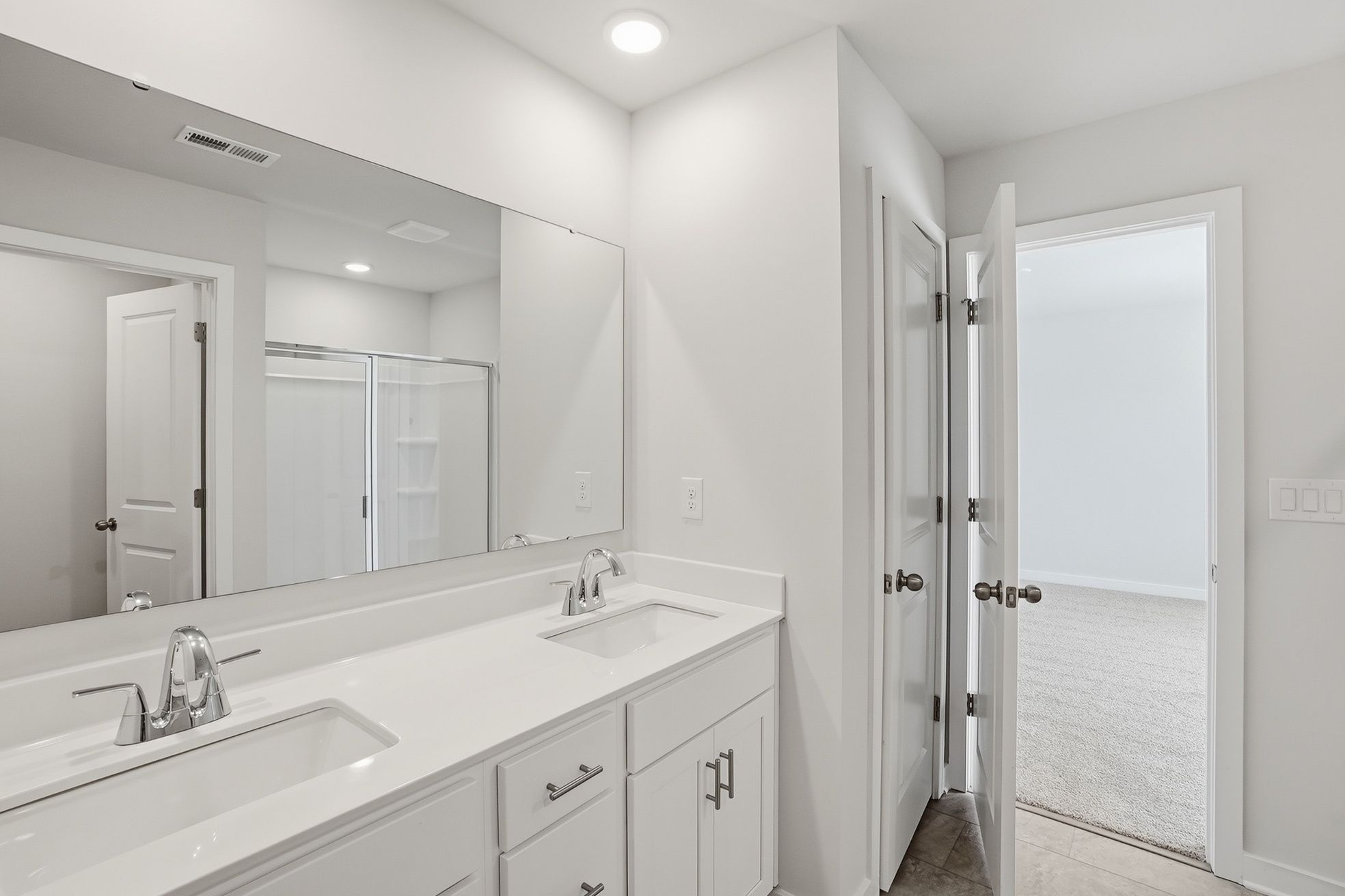 A bathroom with a large mirror.