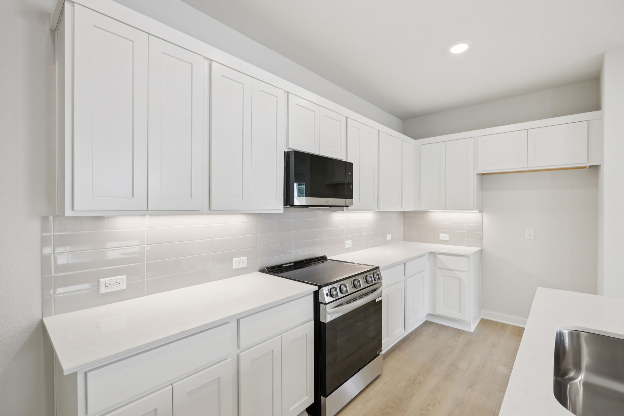 A kitchen with white cabinets.