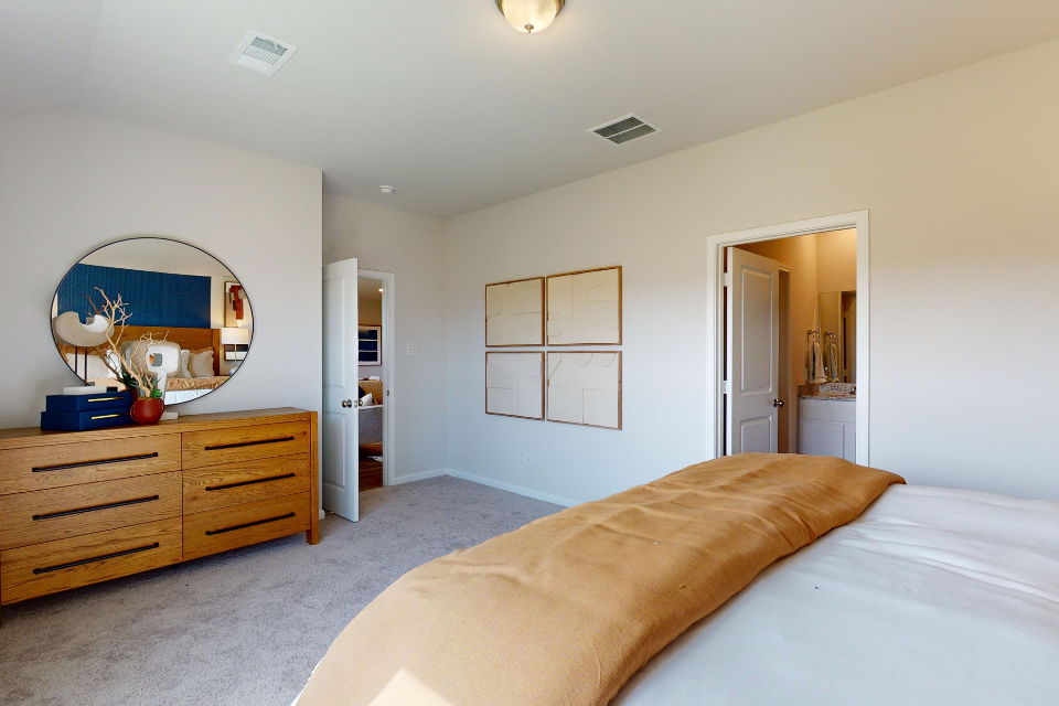 A bedroom with a large mirror.
