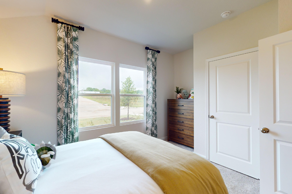 A bedroom with a large window.