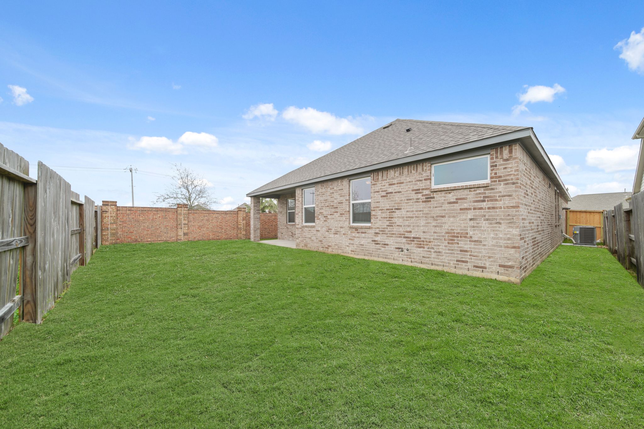 A brick house with a green lawn.
