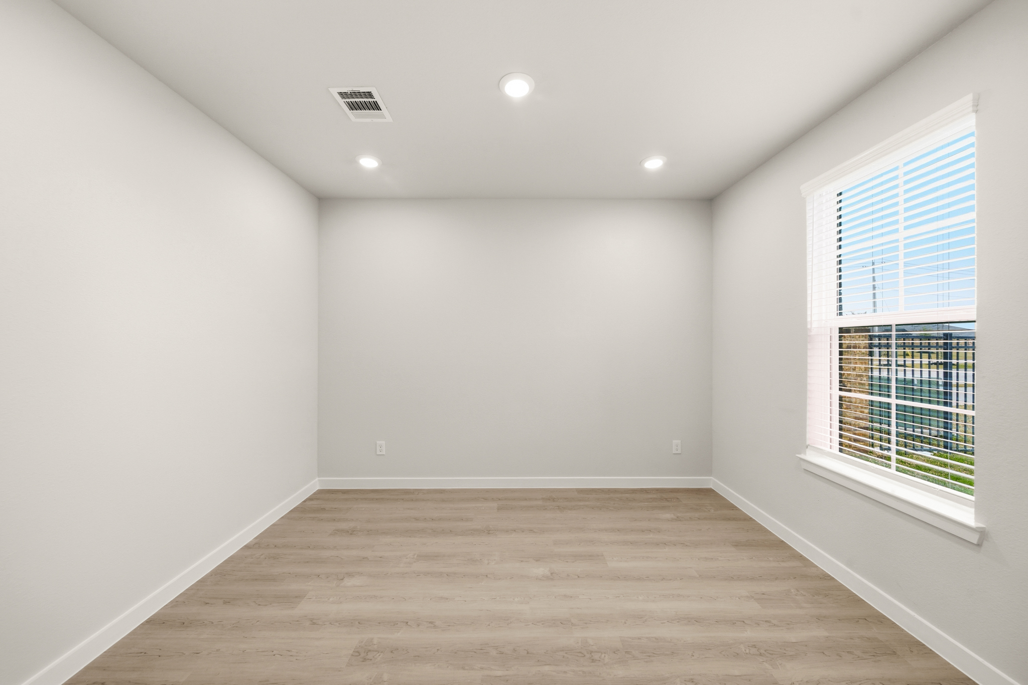 A room with a wood floor and windows.