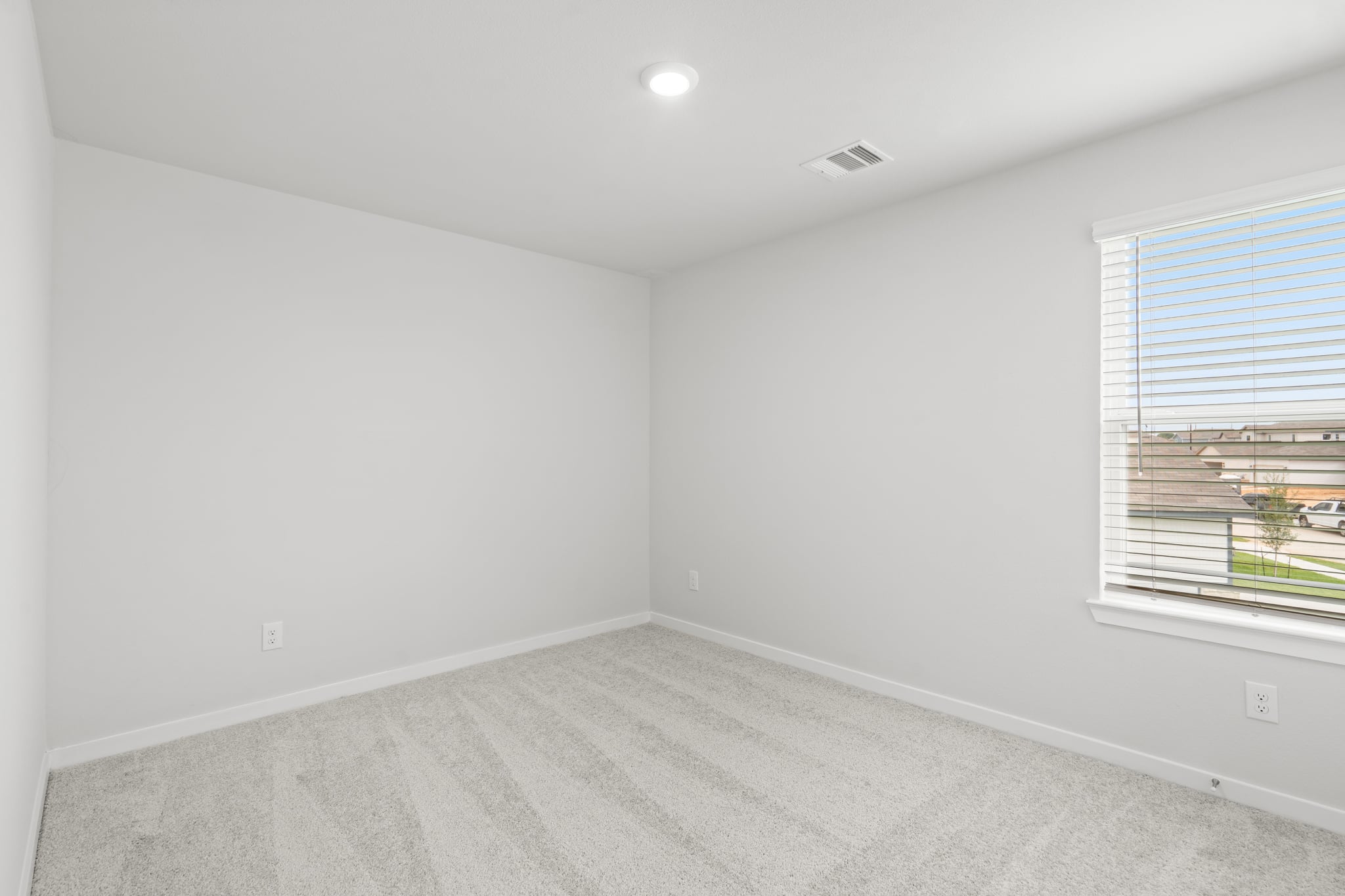 A room with a window and a carpet.