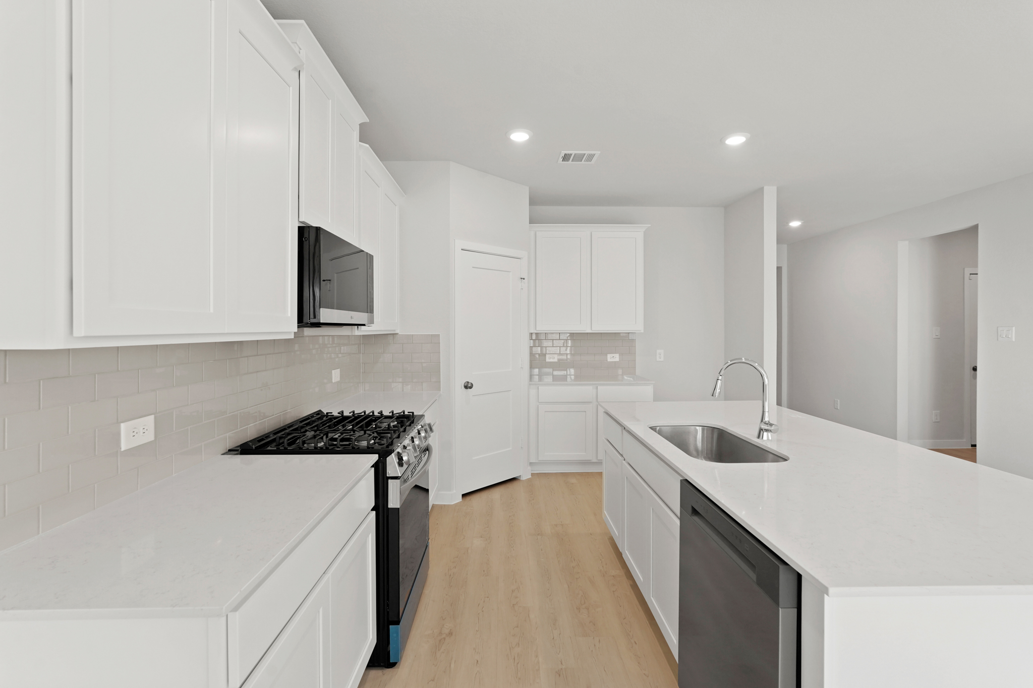 A kitchen with white cabinets.