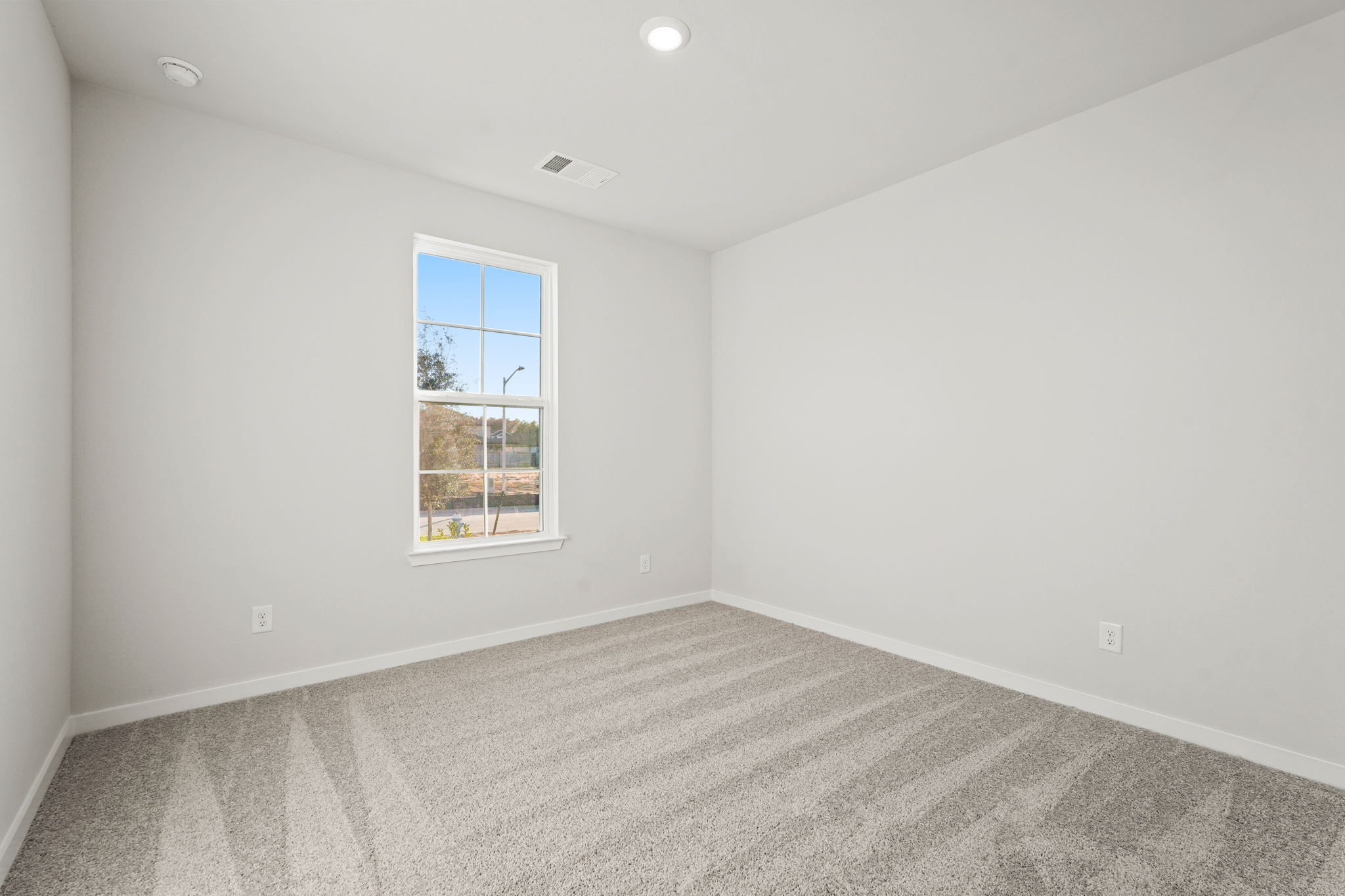 A room with a window and a carpet.