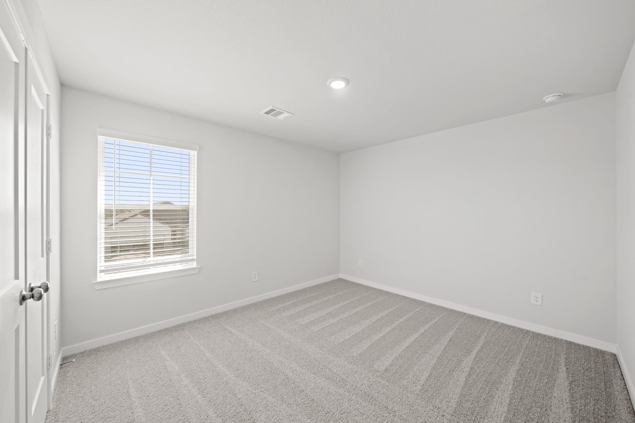 A room with a window and a rug.