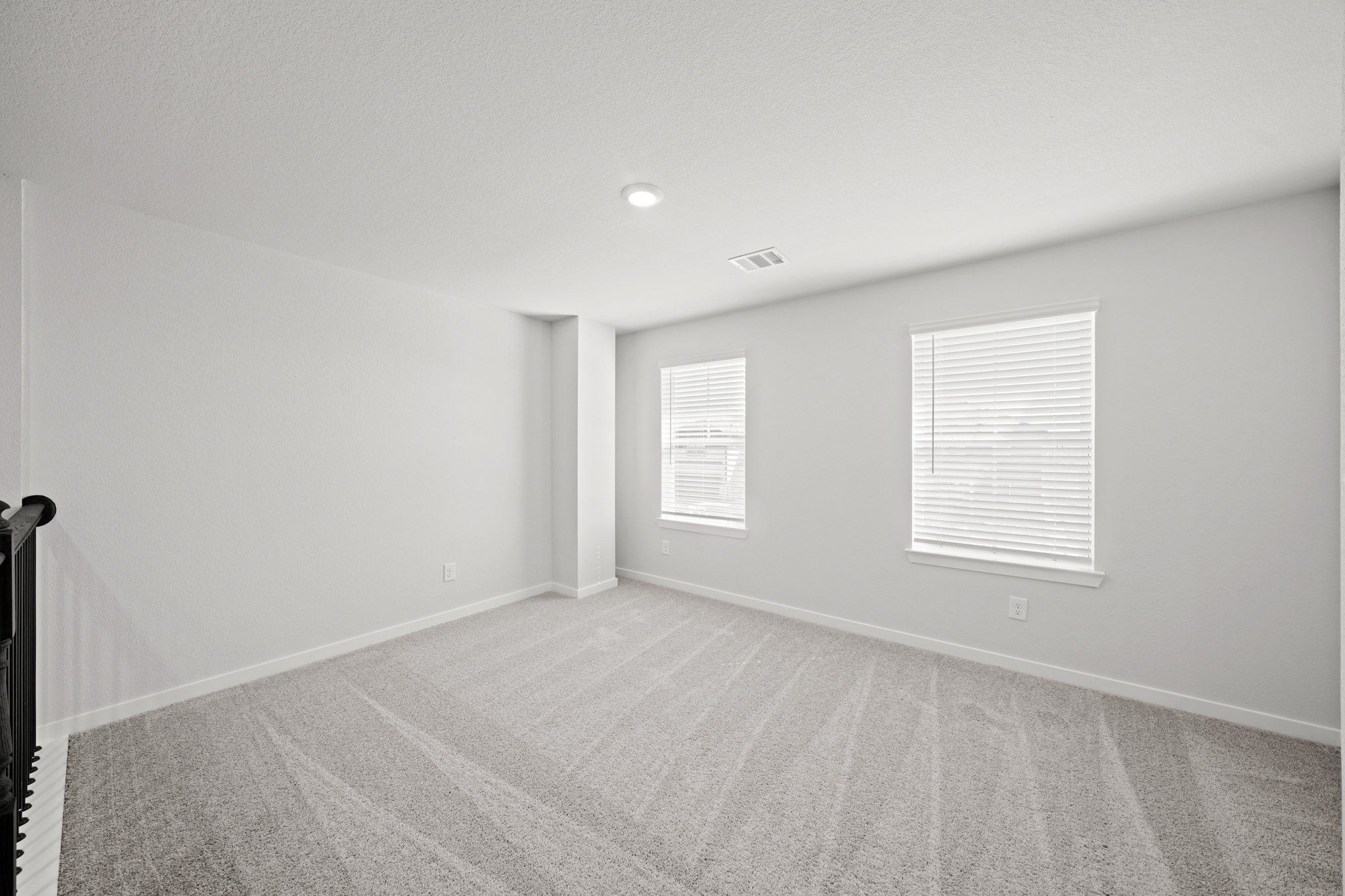 A room with a carpet and windows.