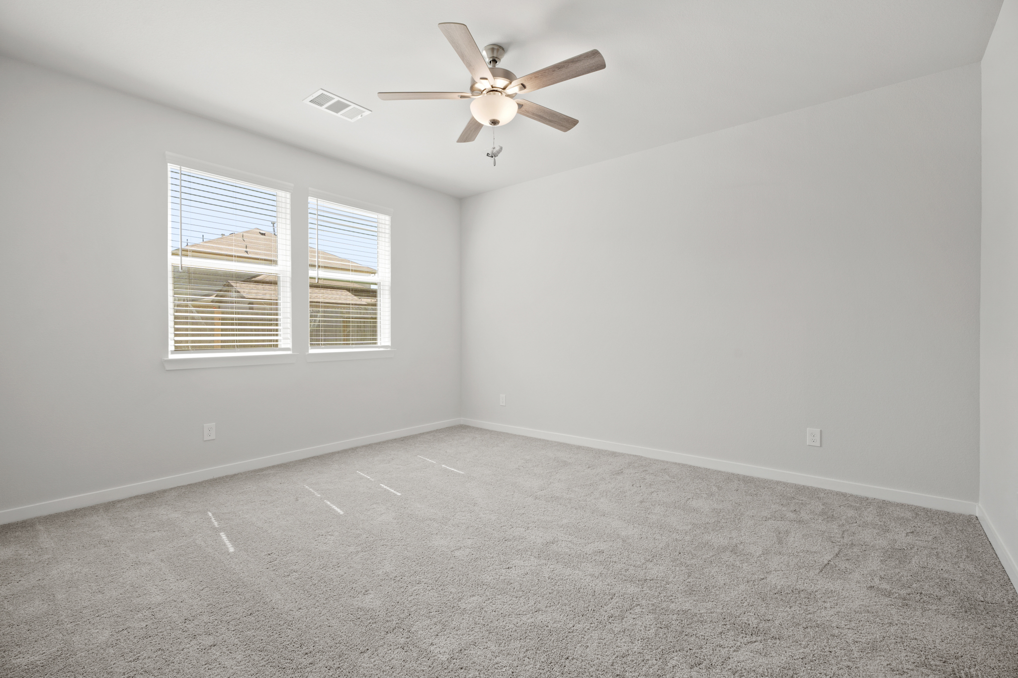 A room with a ceiling fan and a window.