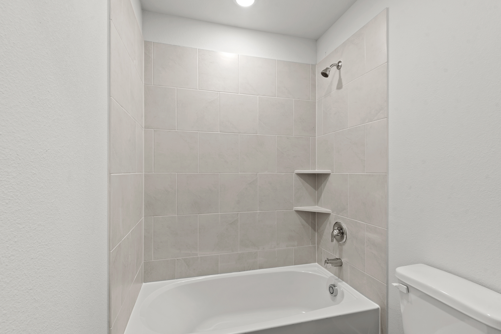 A bathroom with a bathtub and toilet.