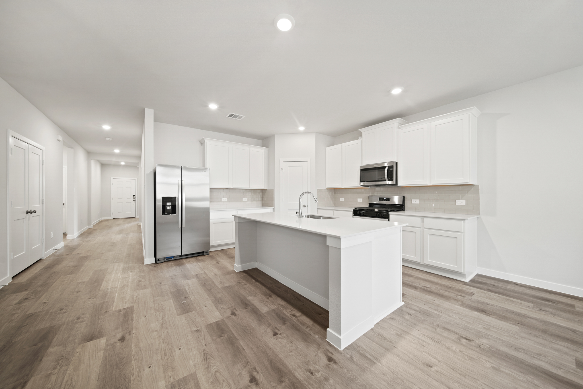 A kitchen with white cabinets.