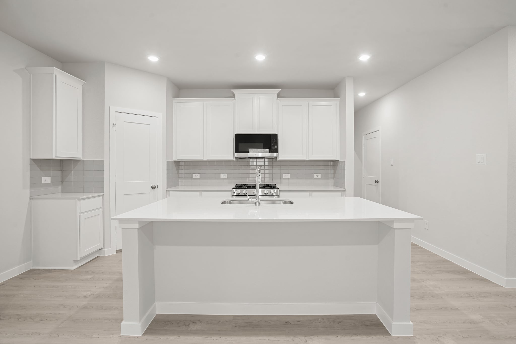 A kitchen with white cabinets.