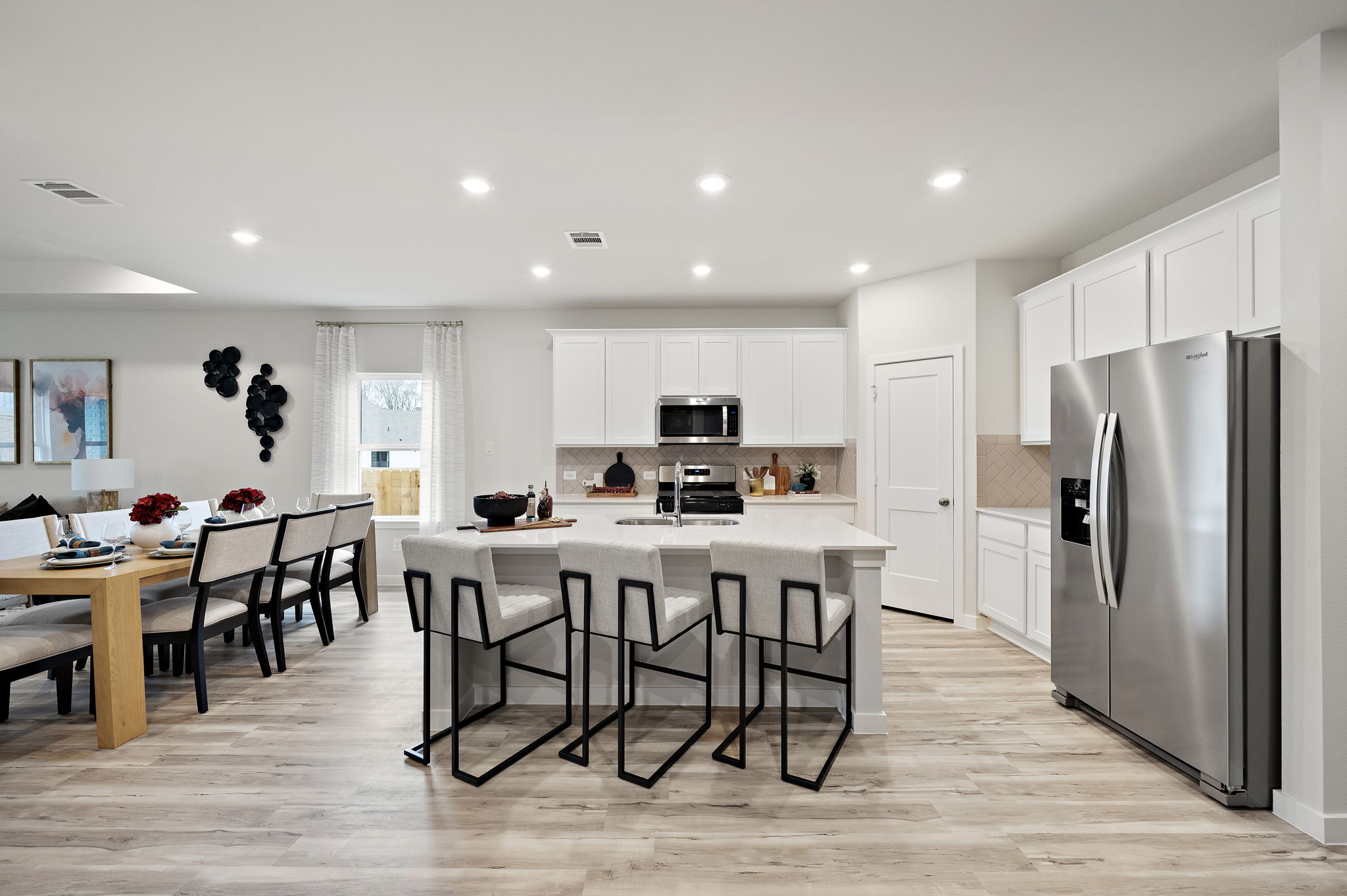 A kitchen with a dining table and chairs.
