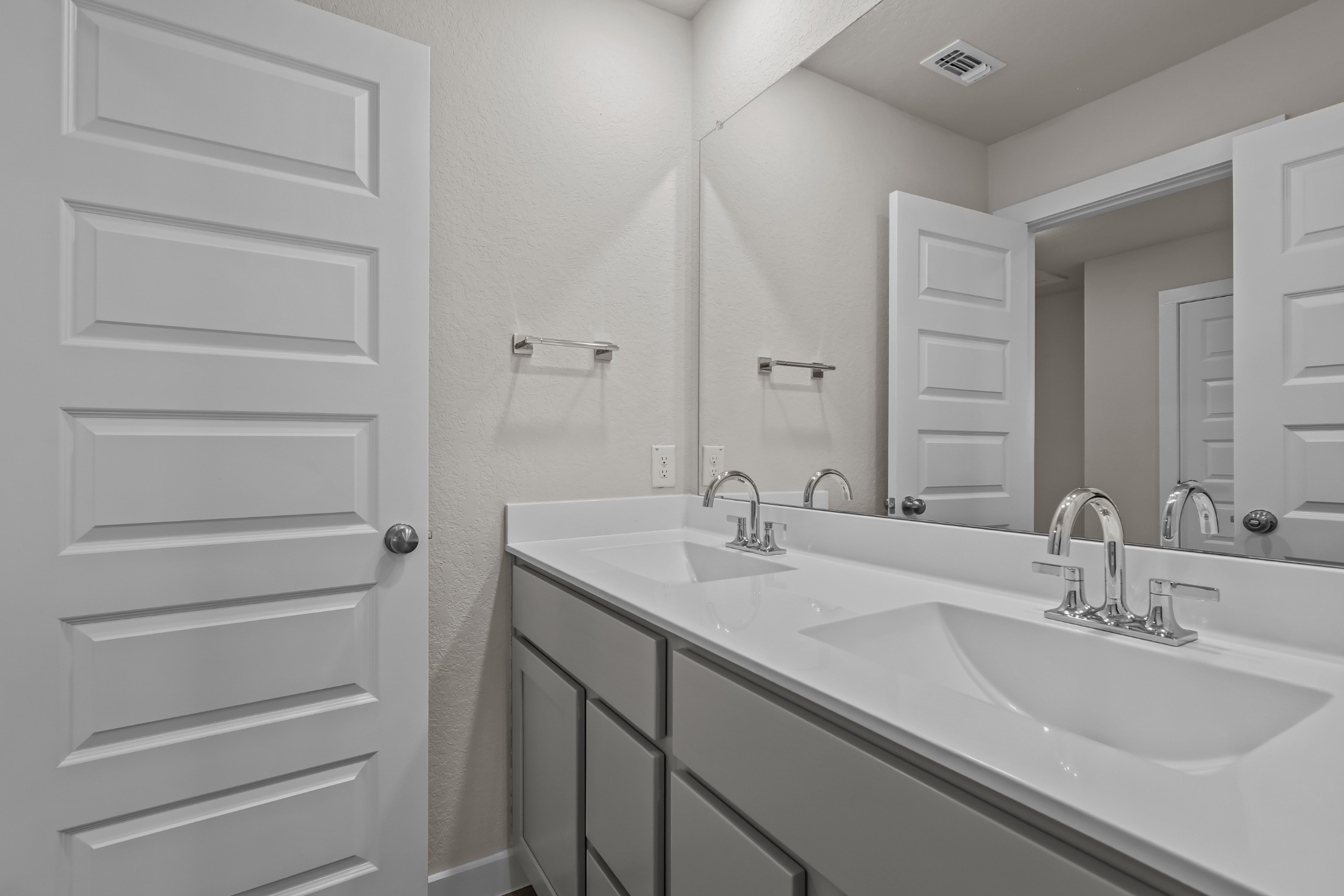 A bathroom with a large mirror.