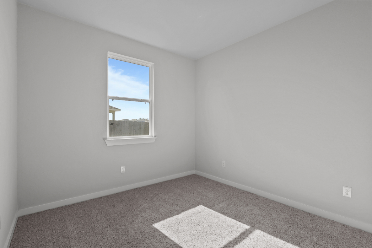 A room with a window and a rug.