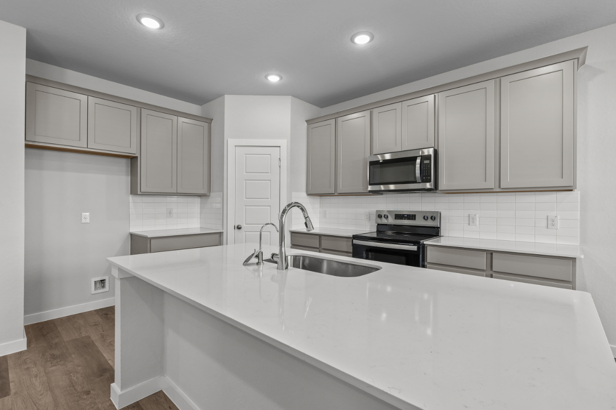 A kitchen with white cabinets.