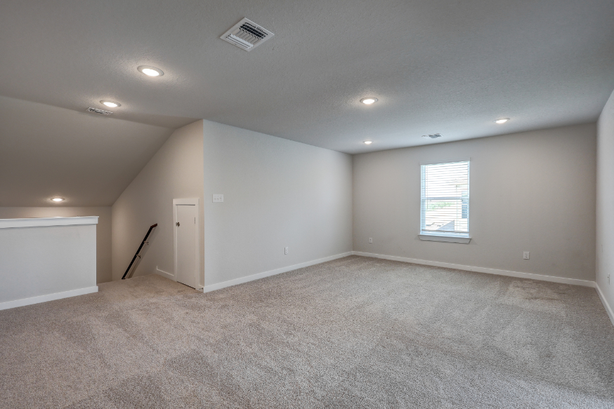 A room with a carpet and a door.