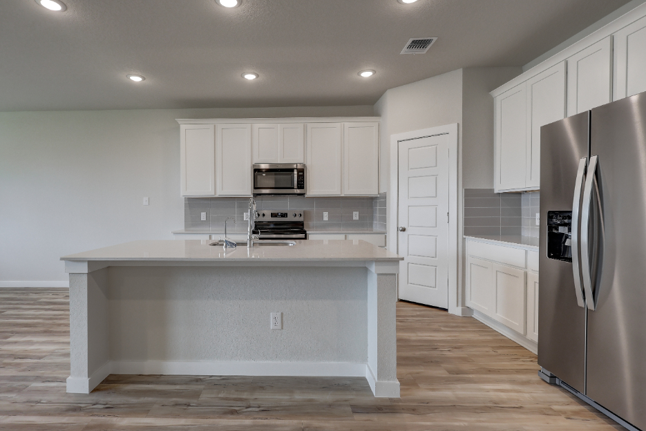 A kitchen with white cabinets.