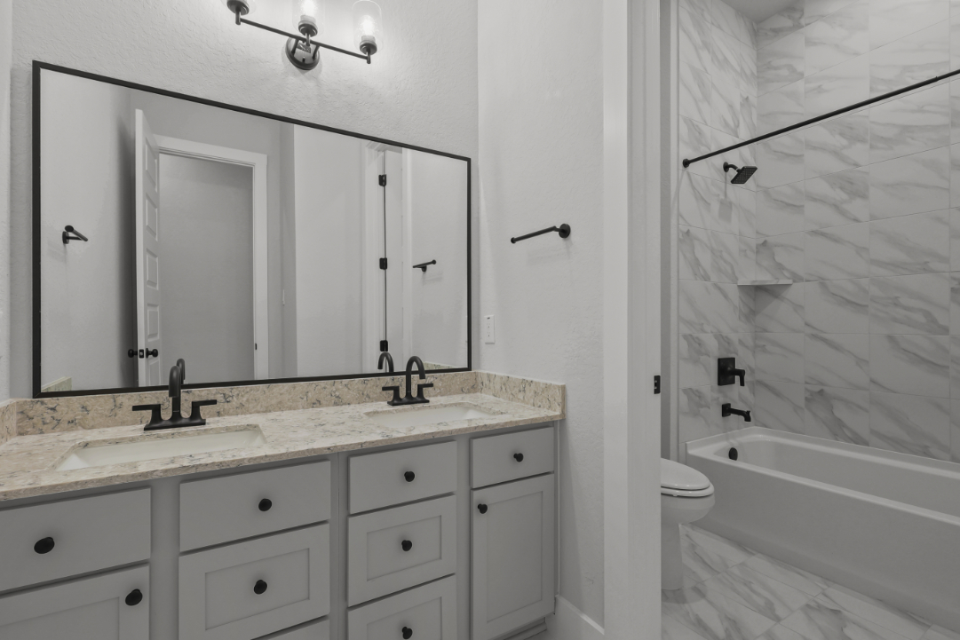 A bathroom with a tub sink and toilet.