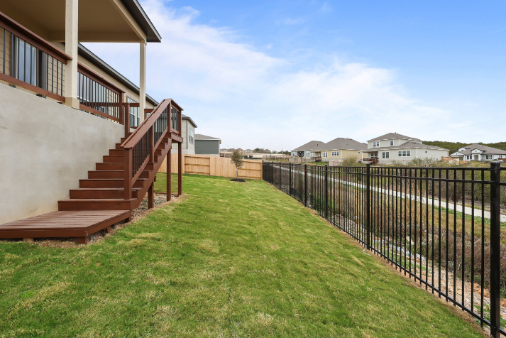 A fenced in yard with a house in the background.