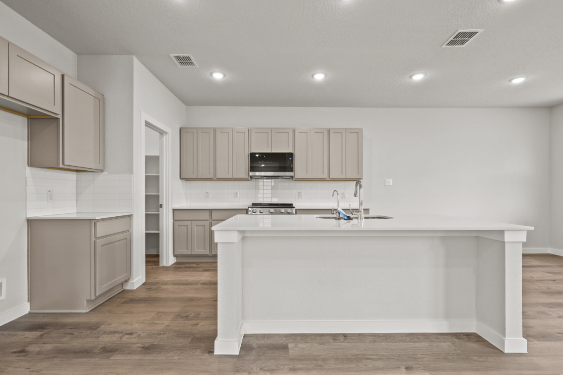 A kitchen with white cabinets.