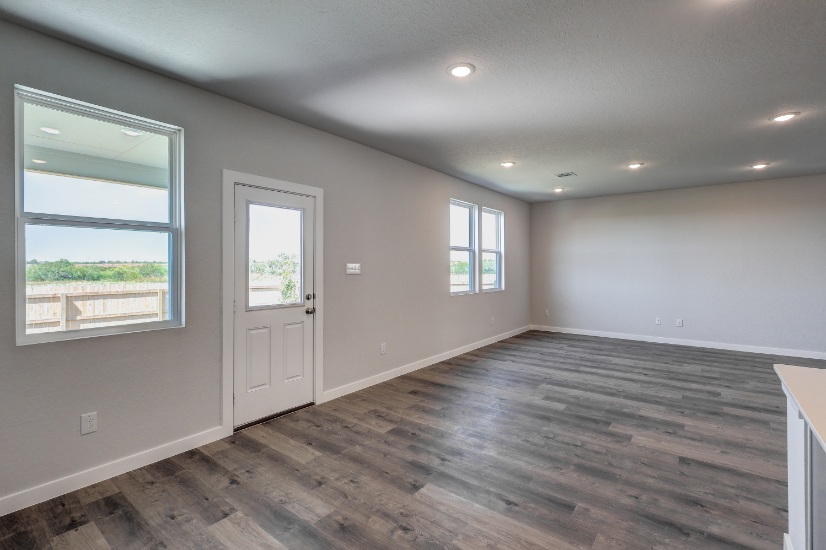 A room with windows and a wood floor.