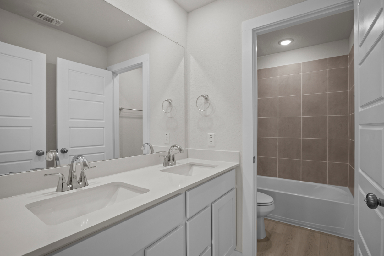 A bathroom with a tub sink and toilet.