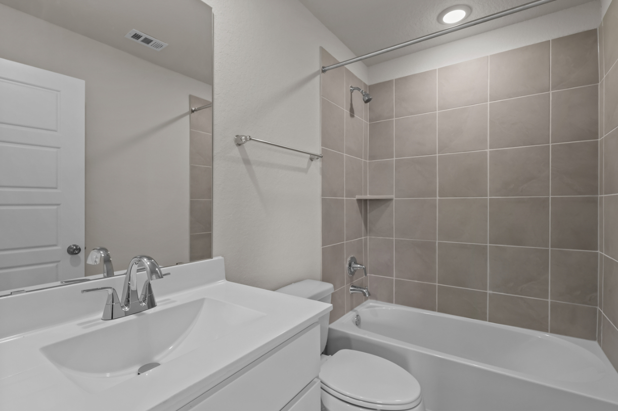 A bathroom with a sink toilet and bathtub.