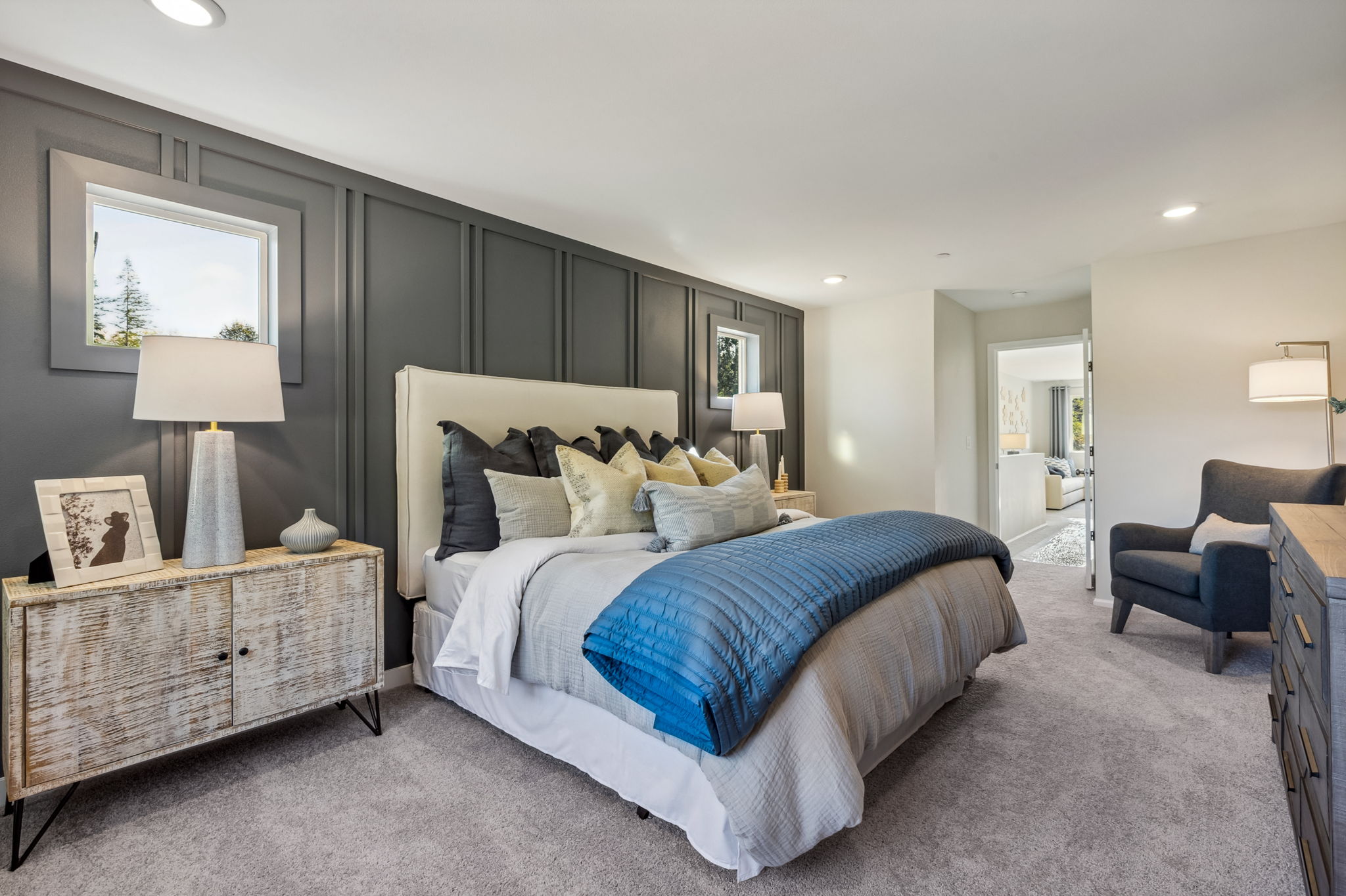 A bedroom with a bed and a chair.